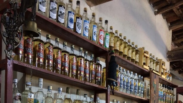 A bar with shelves stocked with various liquor bottles. - Hospedaria e Restaurante Chalé da Serra (Lima Duarte)