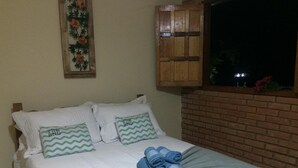 A neatly made bed with white bedding and two pillows with green zigzag patterns. - Hospedaria e Restaurante Chalé da Serra (Lima Duarte)