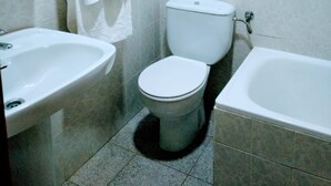 A bathroom with a toilet, sink, and bathtub. - Pensión Cuadrado (Seron)