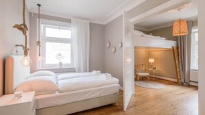 A modern bedroom with a bed, bedside table, and a hanging light fixture.