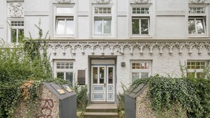 A historic building with ornate architectural details, a central entrance with a double door, and a small plaque above the door.