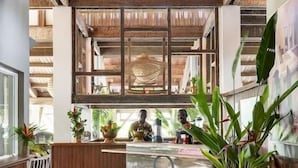 A spacious kitchen with wooden beams, a central island, and a hanging light fixture.