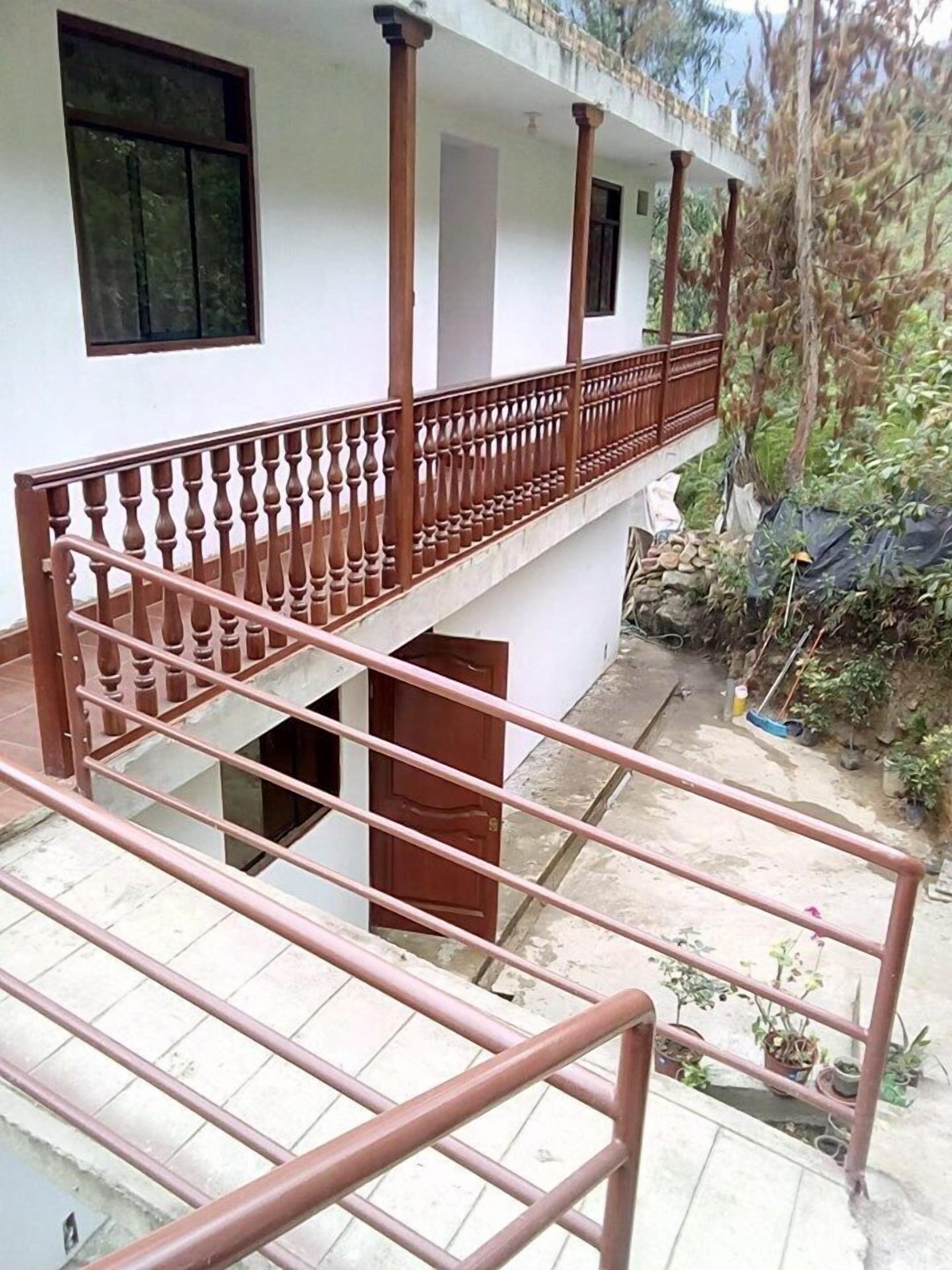 Un edificio de varios niveles con un balcón y una escalera.