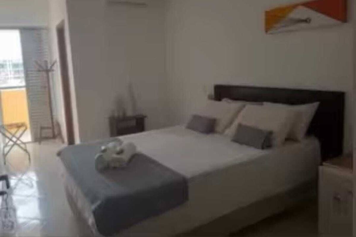 Une chambre à coucher avec un lit, une table de chevet et une œuvre d’art accrochée au mur.