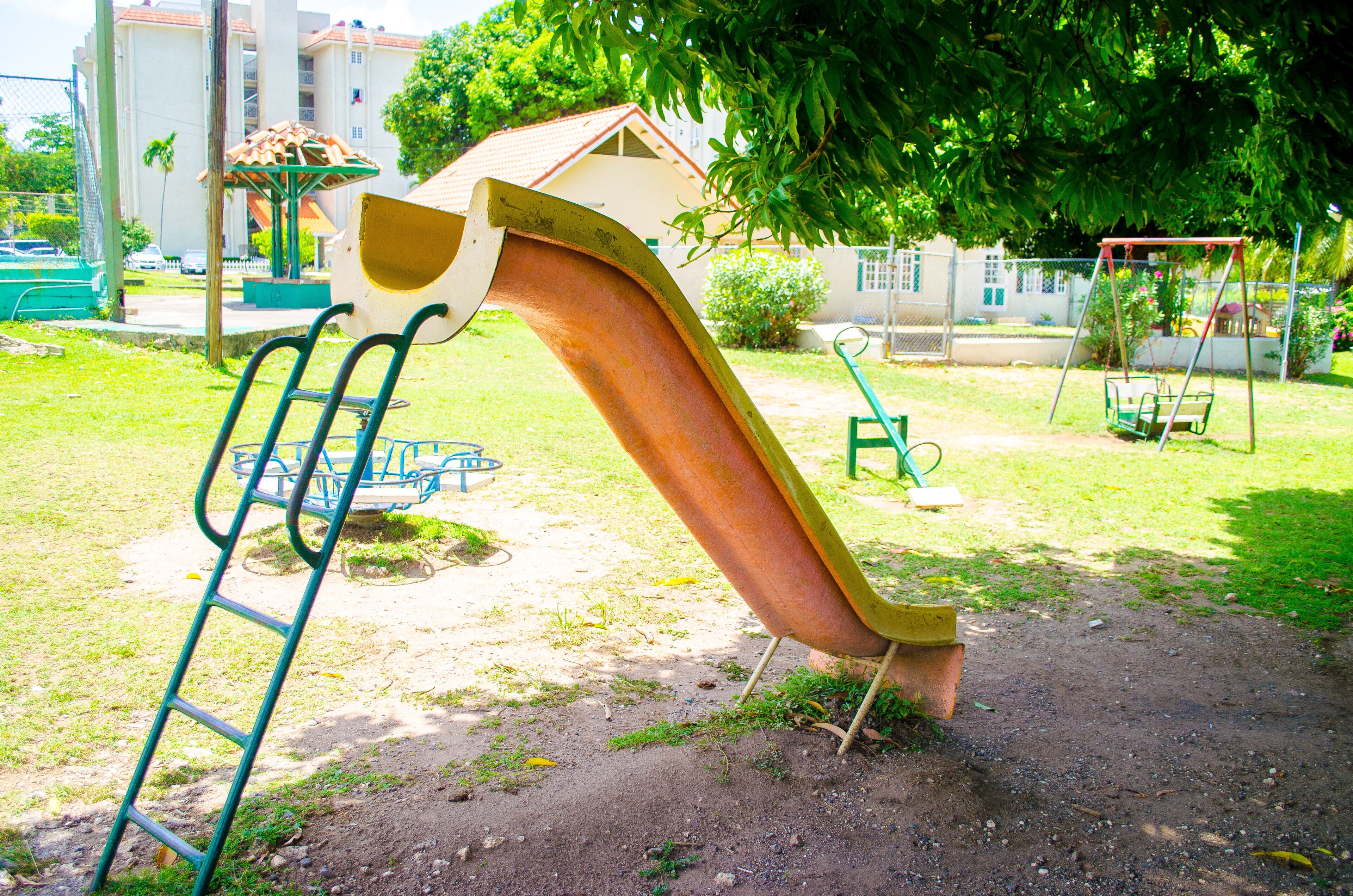 Une aire de jeux avec un toboggan, des balançoires et une structure d’escalade.