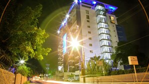 A multi-story hotel with a modern design, featuring a prominent glass facade and illuminated signage. - 20 South Kingston Luxury Apartment (Kingston)
