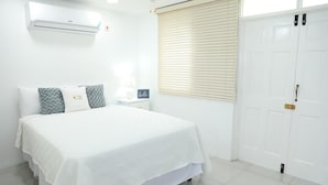 A bedroom with a bed, bedside table, lamp, and a door. - Kingston Guest Apartment At Valencia (Kingston)