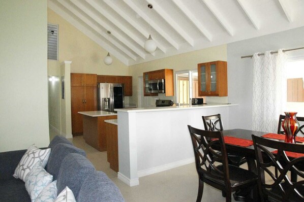 A compact living space with a kitchenette, a dining area, and a sofa.