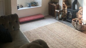 Un soggiorno accogliente con camino, una panca e un divano.