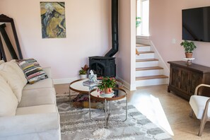 Ein gemütliches Wohnzimmer mit einer Couch, einem Couchtisch, einem Kamin und einer Treppe.