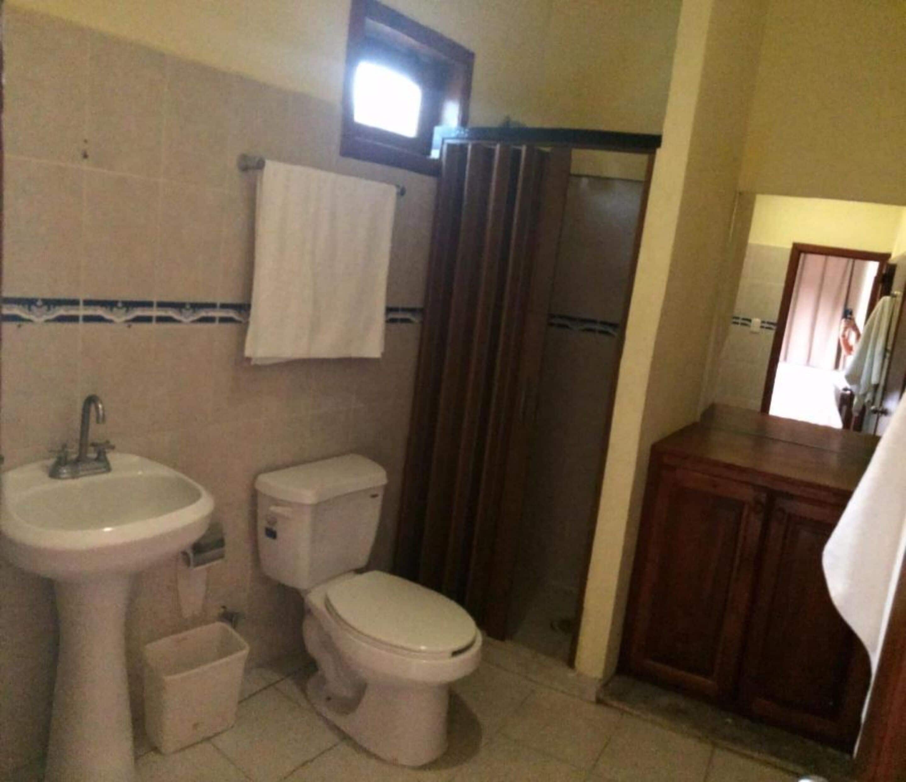 Ein Badezimmer mit Waschbecken, Toilette und Duschvorhang.