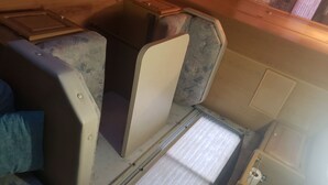 A compact, enclosed space with a small window, a mattress, and a wooden cabinet. - RV Space at Balloon Fiesta Park VIP North Lot (RV Available also) (Albuquerque)