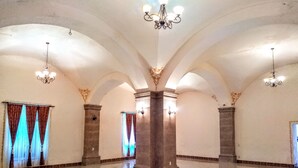 Un vaste hall doté de hauts plafonds, de colonnes en arc de cercle et de lustres.