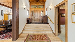 Una scala in legno conduce a una porta da cui si gode una vista sull'esterno.
