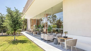 Un espace extérieur aménagé avec des meubles modernes, un chemin et un bâtiment doté de grandes fenêtres.