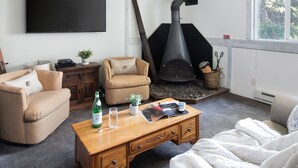A living room with a sofa, armchair, coffee table, fireplace, and a television. - Outpost: Gros Ventre A8 - Hot Tub Access (Teton Village)