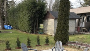 Une terrasse en béton avec des fauteuils Adirondack et un foyer en pierre.