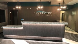 Een receptiebalie bij Havasu Landing Resort & Casino, met een marmeren blad en een houten paneeldecoratie.
