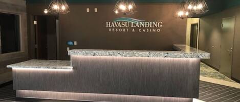Un mostrador de recepción en Havasu Landing Resort & Casino, con encimera de mármol y diseño de paneles de madera.