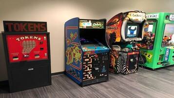 Una hilera de máquinas recreativas con diseños coloridos y una pantalla digital para fichas.