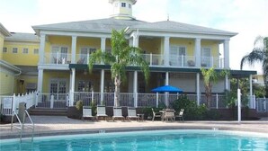 A two-story hotel with a pool, outdoor seating, and a small tower structure on the roof.
