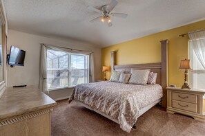 A bedroom with a bed, bedside tables, a ceiling fan, and a TV. - Sharing The Dream Villa by VillaDirect (Kissimmee)
