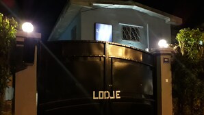 Een hekpoort met een bord waarop 'LODEJ' staat, 's nachts.