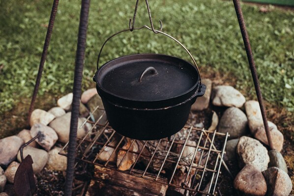 A black pot suspended over a grill with rocks around it. - Water front cottage on beautiful Upper Long Lake (Albion)