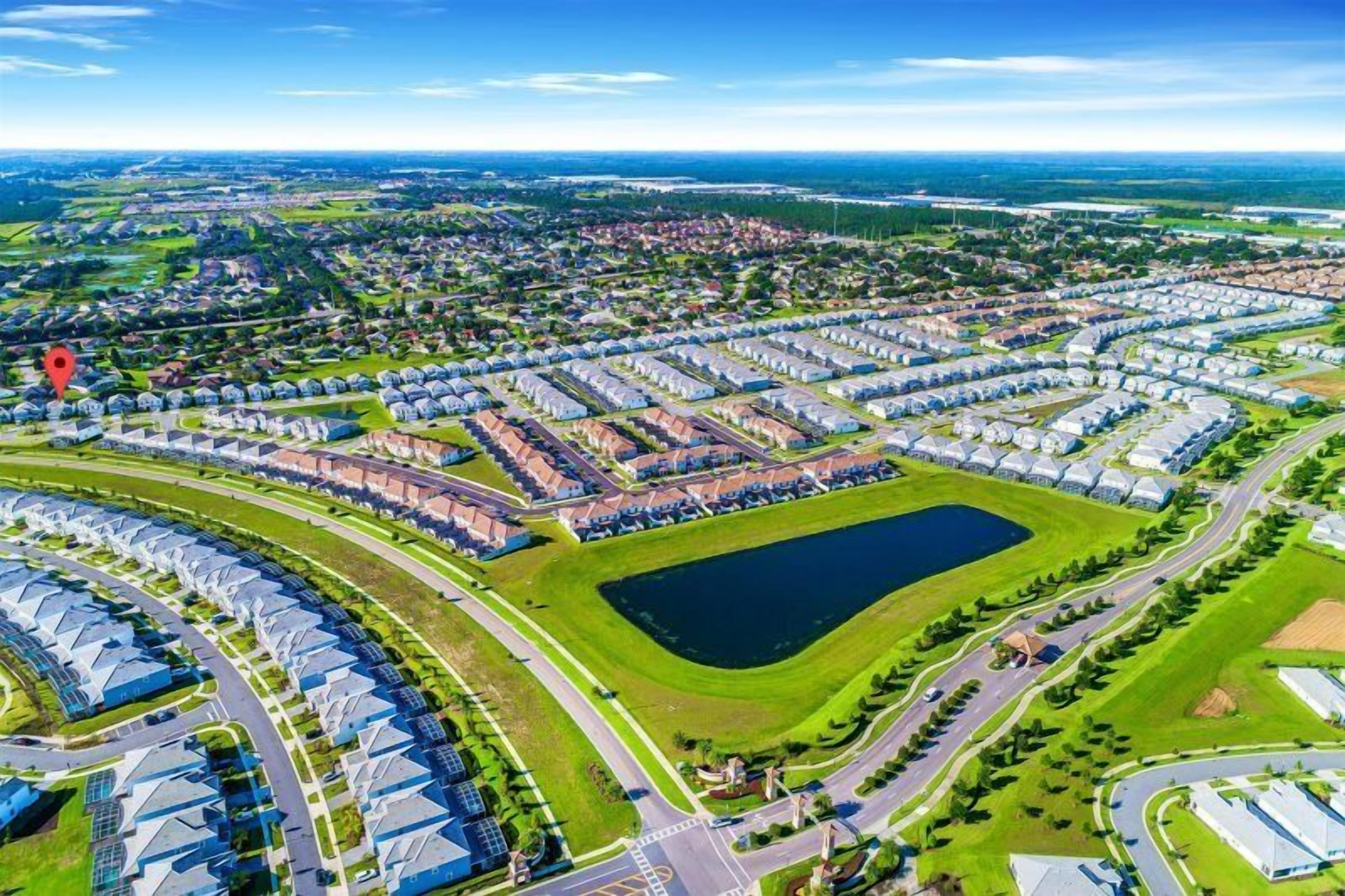 Una vista aerea di una zona residenziale con alloggi ben disposti, uno spazio verde centrale e strade circostanti.
