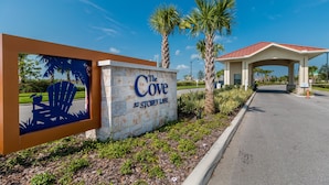 A sign for 'The Cove at Storey Lane' with a beach scene, palm trees, and a covered entrance.