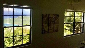 A room with two windows offering views of a coastal landscape and a map on the wall. - Virgin Island Villa Suite, View, Private Pool & Hot Tub! (St. Thomas)