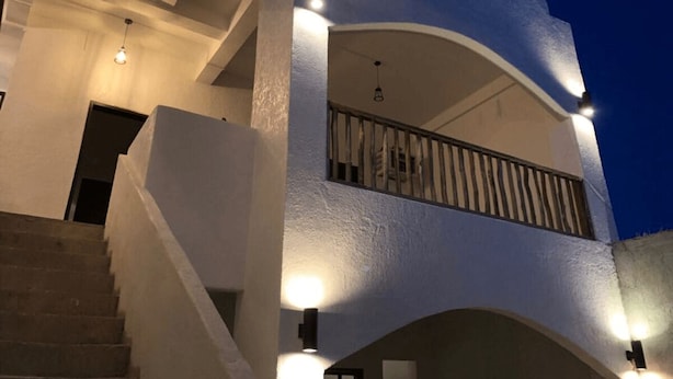A multi-level building with a staircase, balconies, and exterior lighting. - Sentro Suites Siargao (General Luna)