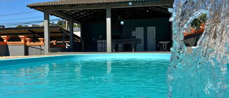 A clear blue pool with a building in the background.