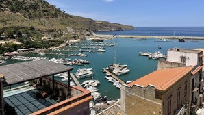 Un port de plaisance où sont amarrés de nombreux bateaux, entouré de bâtiments et d’un paysage vallonné.