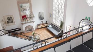 A spacious living room with a large window, a fireplace, and a sofa.