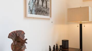 Et værelse med et trækonsolbord, en lampe, et billedramme og et lille ur.