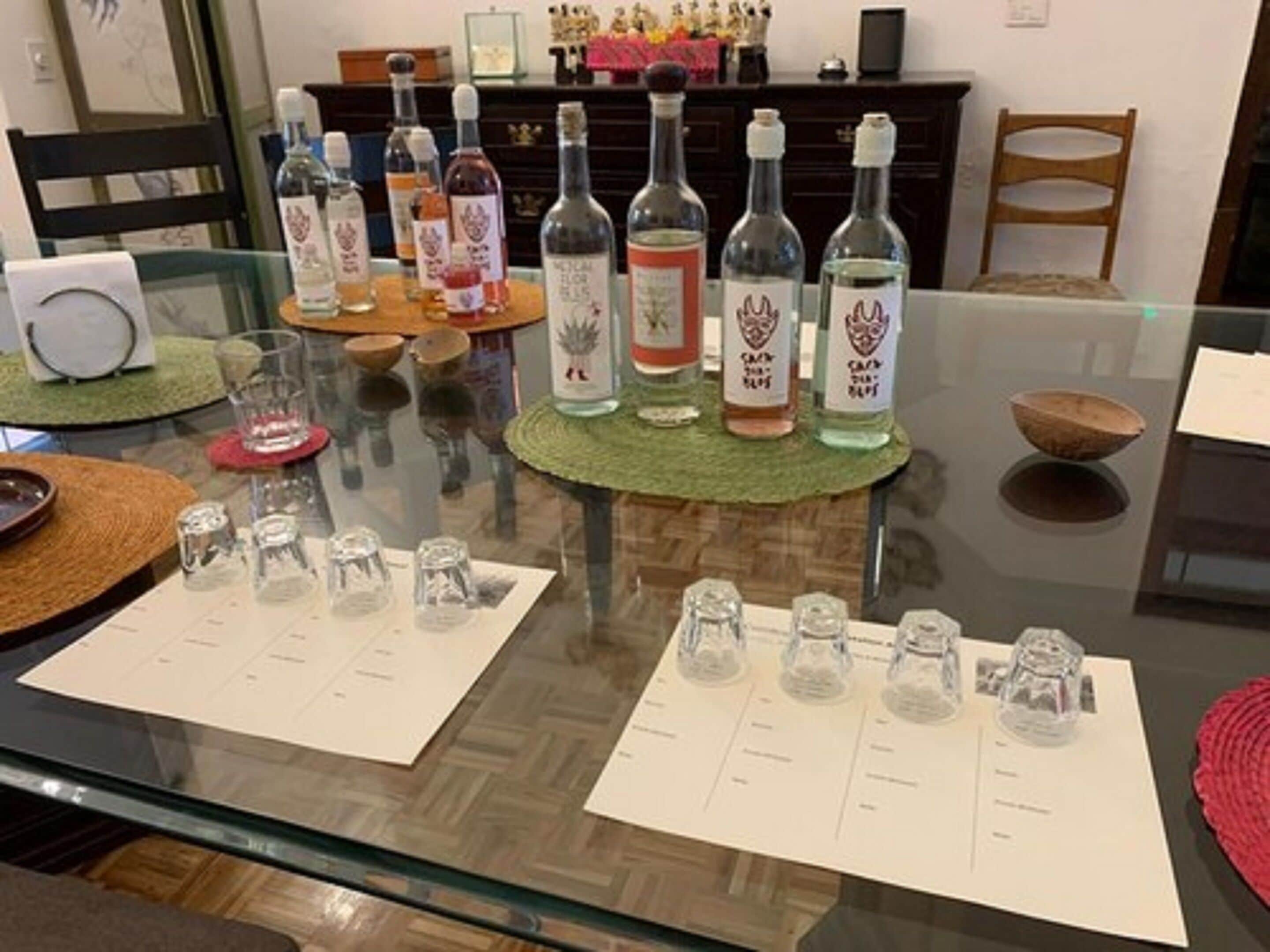 A dining table with multiple bottles and glasses, a menu, and a decorative bowl.