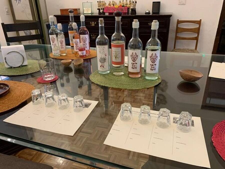 A dining table with multiple bottles and glasses, a menu, and a decorative bowl.