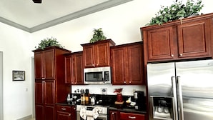 A modern kitchen with dark wood cabinets, stainless steel appliances, and a granite countertop.