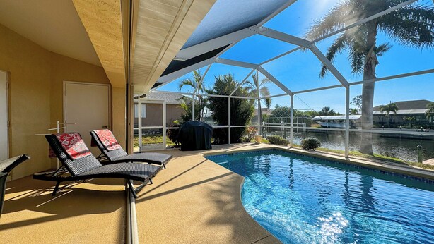 Ein Poolbereich mit Liegestühlen und einer überdachten Terrasse.