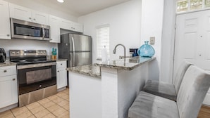 A modern kitchen with stainless steel appliances, a granite countertop, and a built-in oven.