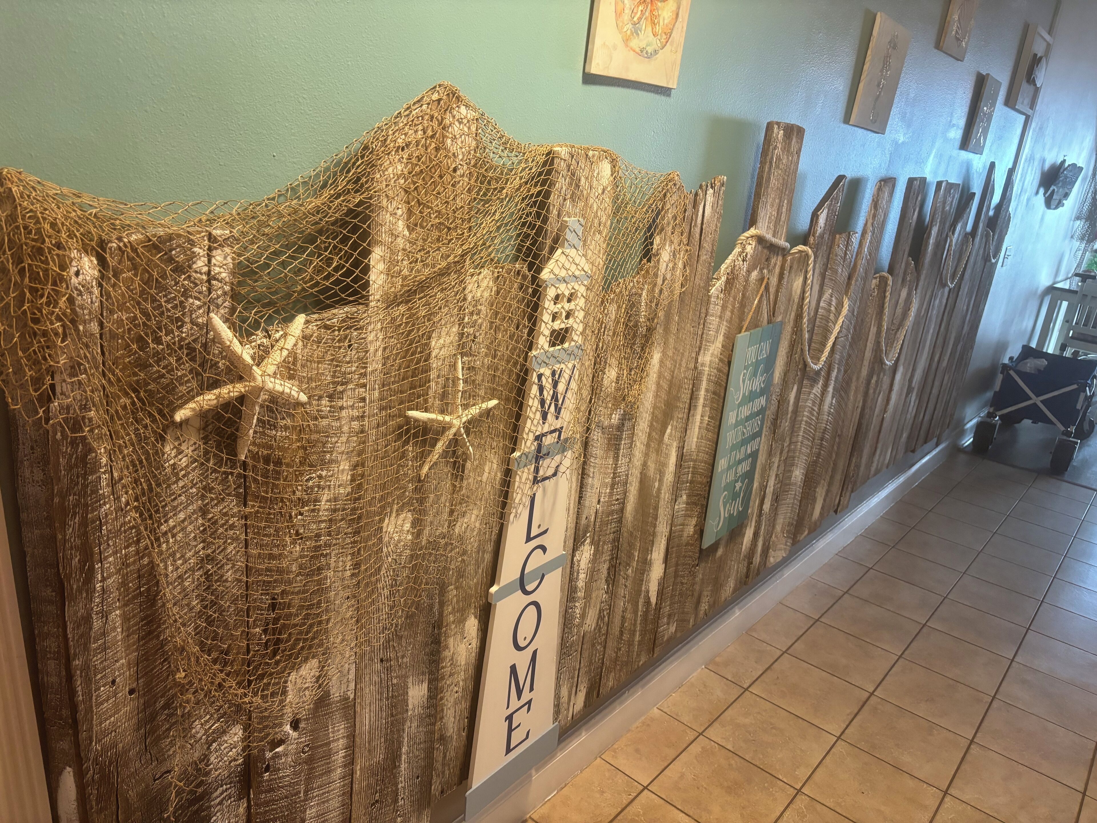 A wooden wall with a netted design and a 'WELCOME' sign.