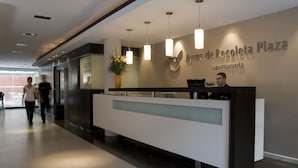 A reception desk with a modern design, a logo above it, and a sign indicating it's an apartment complex.