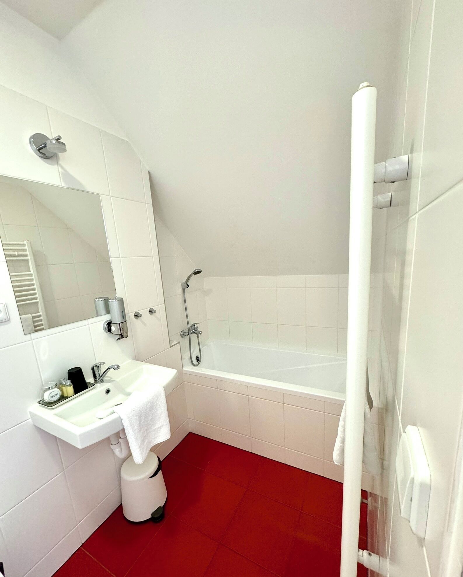 A bathroom with a white sink, mirror, and bathtub.