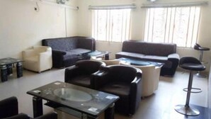 A living room with a sofa, armchairs, a coffee table, and a bar stool. - De Villa Hotel and Suites (Badagry)