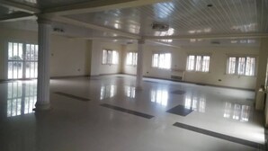 A spacious, empty room with large windows, white columns, and a polished floor. - De Villa Hotel and Suites (Badagry)