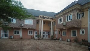A hotel with a central entrance, multiple windows, and air conditioning units. - De Villa Hotel and Suites (Badagry)
