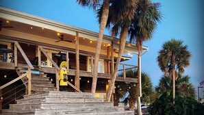 Un immeuble à plusieurs étages, doté d’une façade en bois et d’un escalier menant à l’entrée.