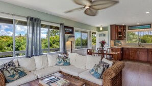 A spacious living room with a white sofa, a coffee table, and a ceiling fan. - Relax at Kapakai Cottage – 2-Bedroom Comfort with Full Kitchen & W/D (Kailua)