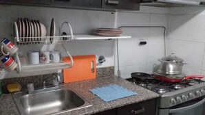A kitchen with a sink, stove, and dish rack. - Apartamento en Altos de Santa Maria Condado del Rey, Imajo (San Miguelito)